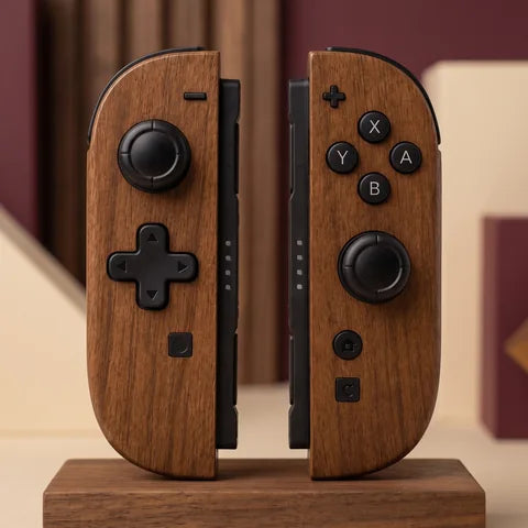 Wood grain Switch 2 Joy-Con pair with black D-pad and black controls on a grounded wood surface